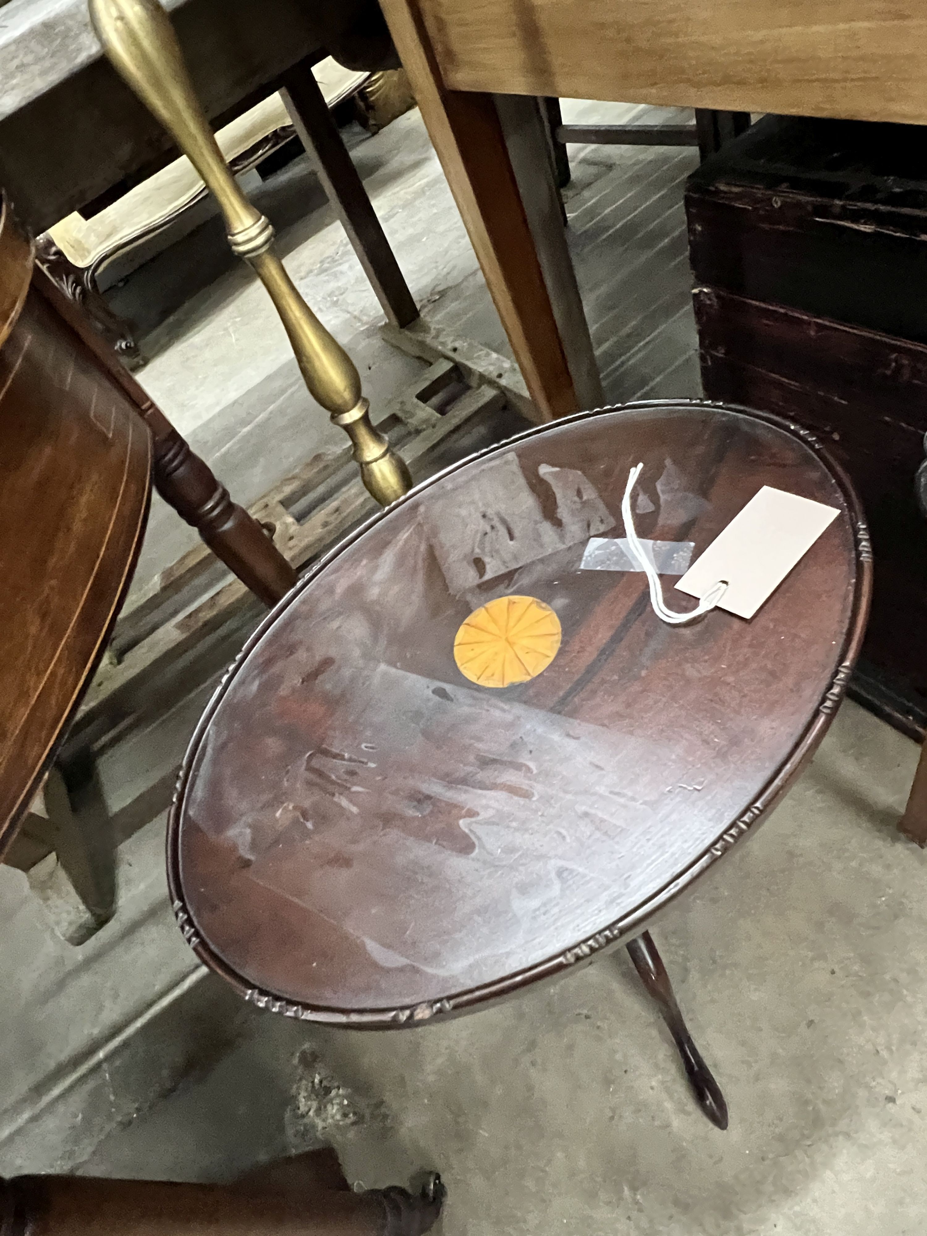 A brass standard lamp on scrolled supports and an oval top mahogany tripod wine table